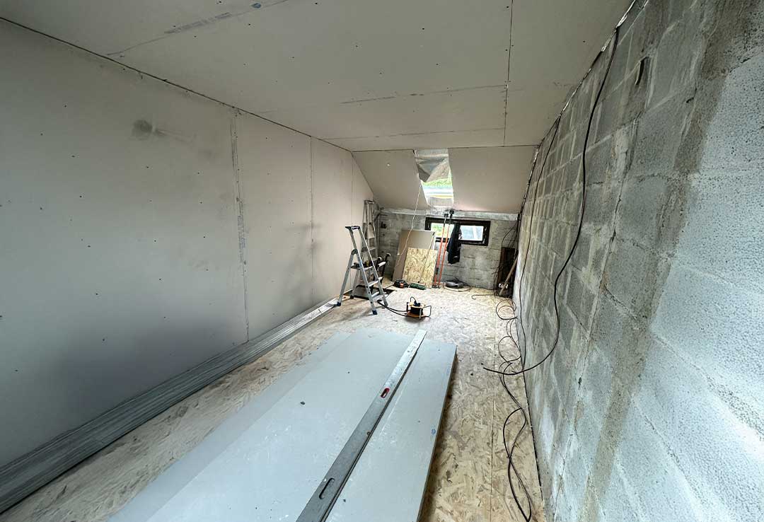 Installation de plaques de plâtre et préparation des finitions pour un aménagement de combles sur mesure