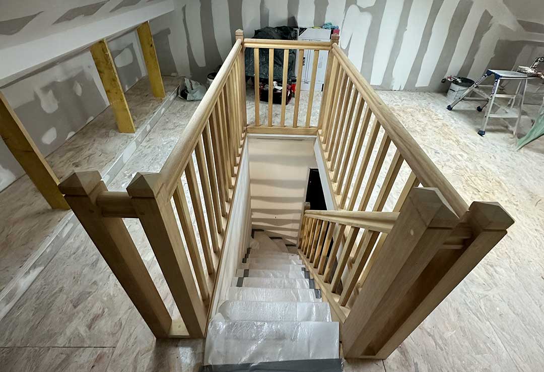 pose de l’escalier en bois avec garde-corps sous les toits